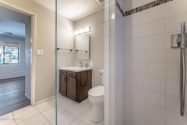 bathroom featuring a shower, tile patterned floors, vanity, and toilet