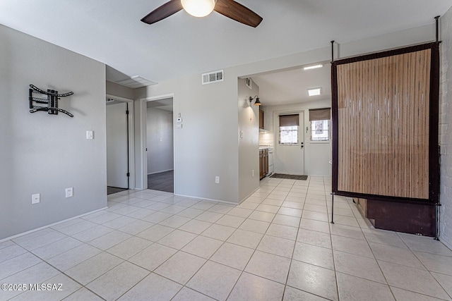 empty room with ceiling fan and light tile patterned floors