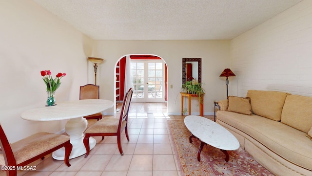 tiled dining room featuring french doors and a textured ceiling