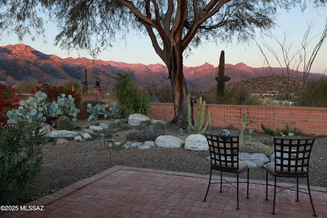 patio terrace at dusk featuring a mountain view