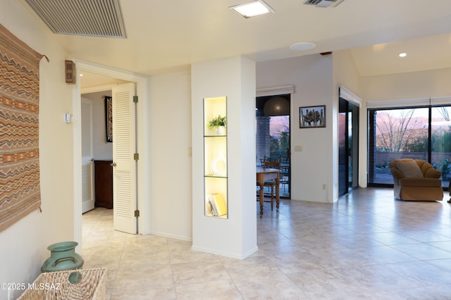 corridor with light tile patterned floors, recessed lighting, visible vents, and baseboards