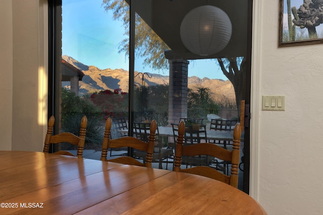 dining space featuring a textured wall and a mountain view