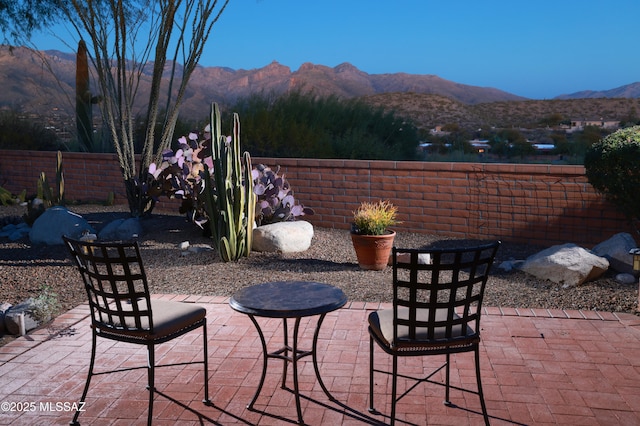 view of patio / terrace featuring a mountain view and fence