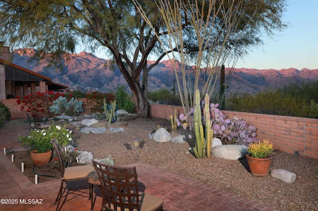 view of yard with a patio area, fence, and a mountain view