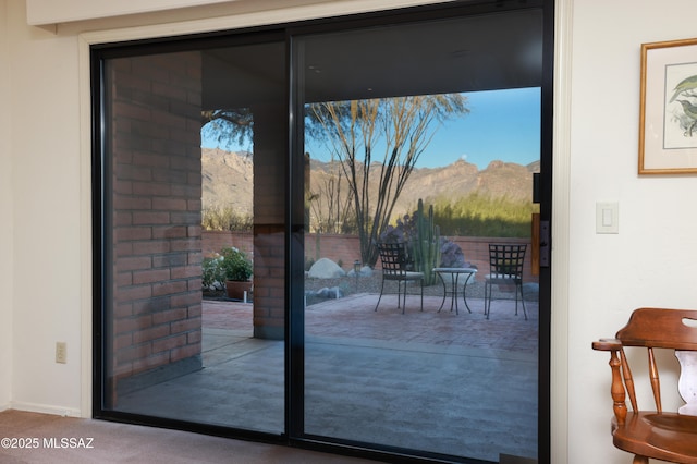 doorway to outside with carpet flooring and a mountain view