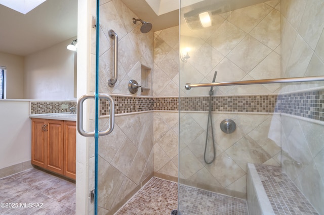 bathroom featuring an enclosed shower, vanity, and tasteful backsplash