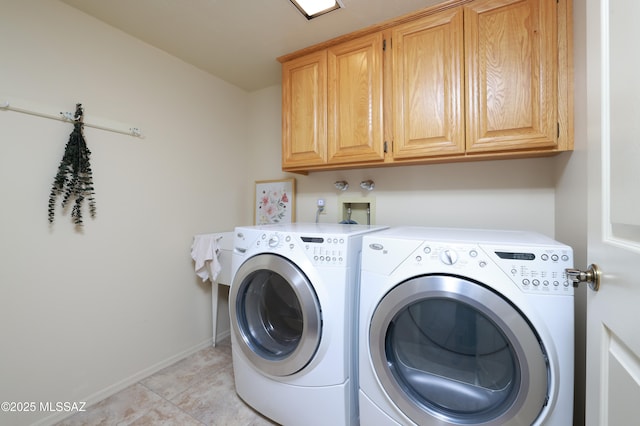 clothes washing area featuring light tile patterned flooring, washing machine and clothes dryer, and cabinets