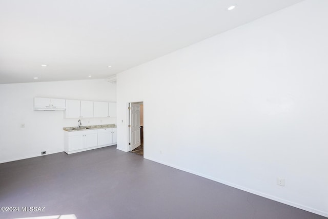 spare room with lofted ceiling and sink