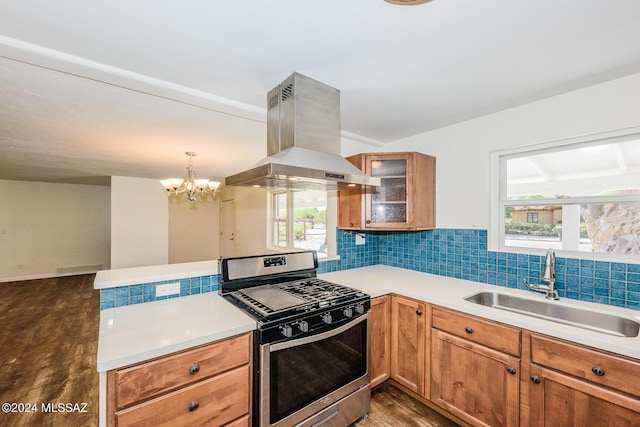 kitchen with island range hood, gas stove, a wealth of natural light, sink, and an inviting chandelier