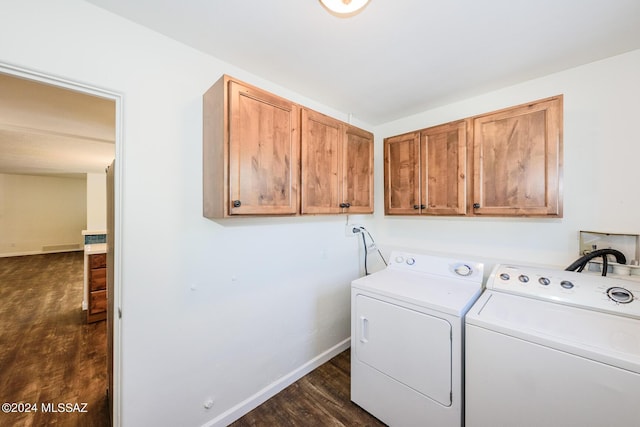 laundry room featuring dark hardwood / wood-style flooring, cabinets, and washing machine and dryer