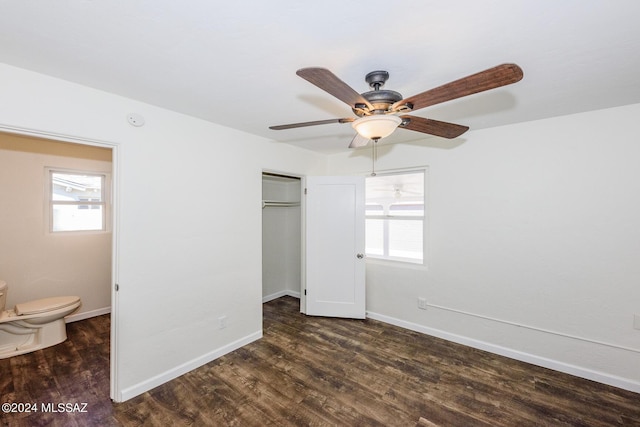 unfurnished bedroom with dark wood-type flooring, ceiling fan, a closet, and multiple windows