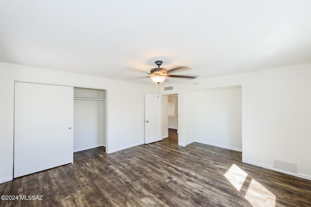 unfurnished bedroom with ceiling fan, a closet, and dark hardwood / wood-style floors