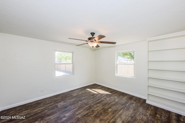 empty room featuring ceiling fan, a wealth of natural light, and dark hardwood / wood-style floors