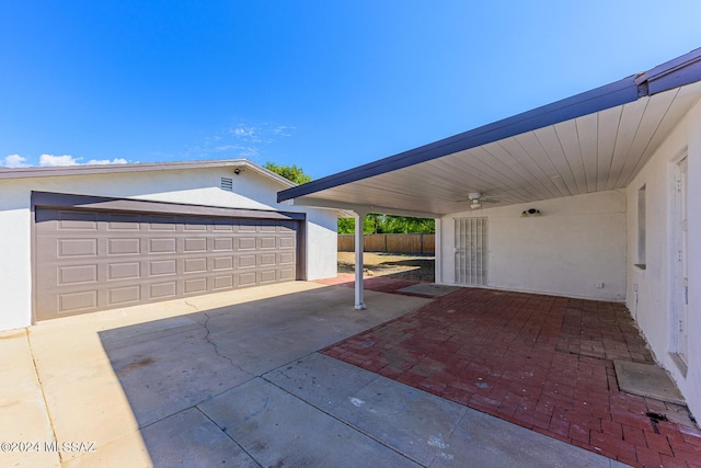 view of patio / terrace featuring a carport, a garage, and an outbuilding