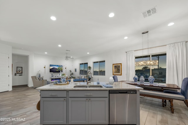 kitchen with sink, gray cabinetry, dishwasher, an island with sink, and pendant lighting