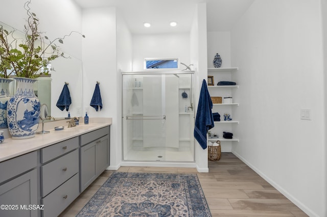 bathroom with hardwood / wood-style flooring, vanity, and a shower with shower door