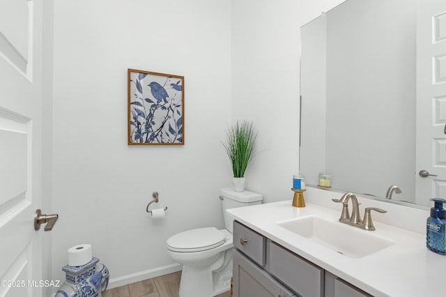 bathroom featuring vanity, wood-type flooring, and toilet