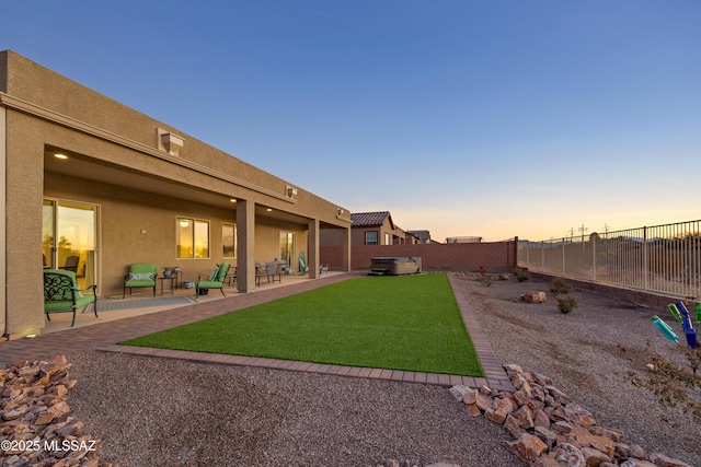 yard at dusk featuring a patio