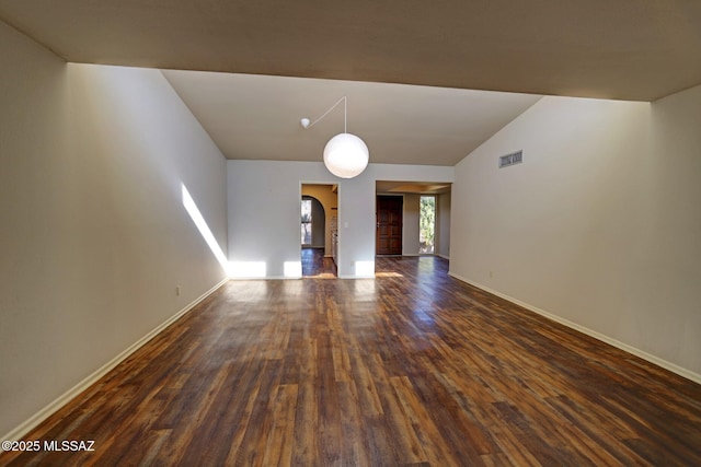 unfurnished living room with vaulted ceiling and dark wood-type flooring