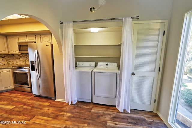 clothes washing area featuring dark wood-type flooring and washing machine and clothes dryer