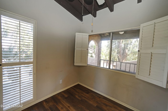 unfurnished room featuring dark wood-type flooring, ceiling fan, and vaulted ceiling with beams