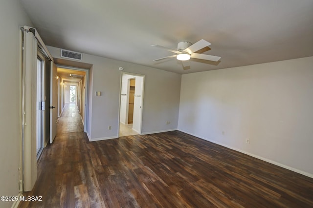 empty room featuring dark wood-type flooring and ceiling fan