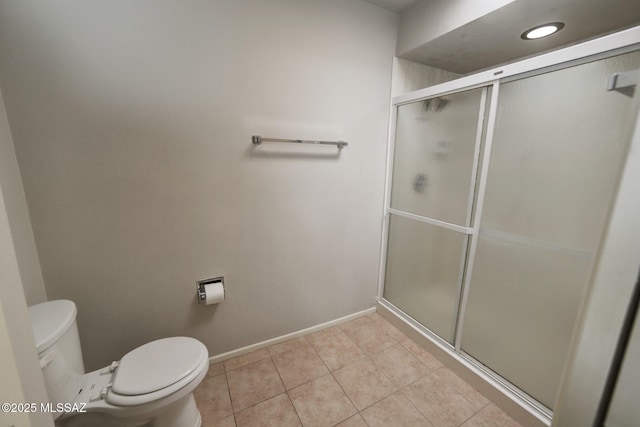 bathroom featuring toilet, walk in shower, and tile patterned floors