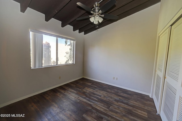 unfurnished bedroom featuring ceiling fan, dark wood-type flooring, a closet, and vaulted ceiling with beams