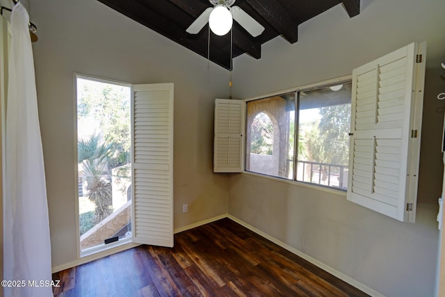 empty room with a healthy amount of sunlight, ceiling fan, dark hardwood / wood-style flooring, and lofted ceiling with beams