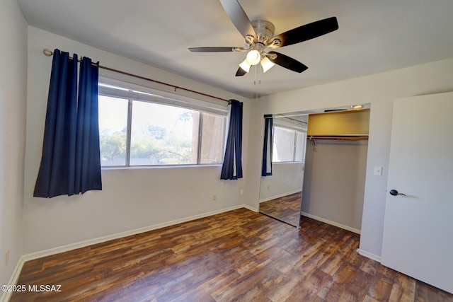 unfurnished bedroom with ceiling fan, dark wood-type flooring, and a closet