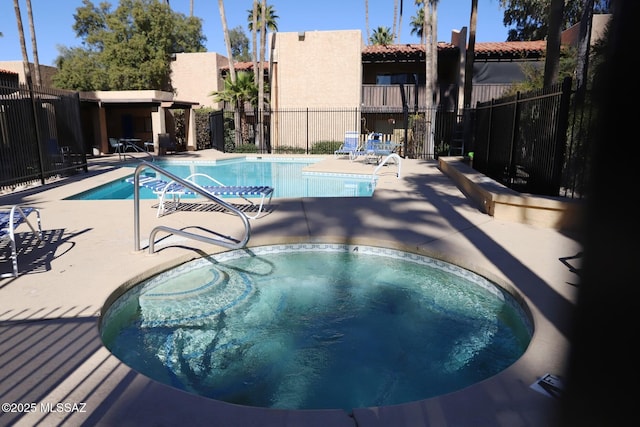 view of swimming pool with a hot tub and a patio area