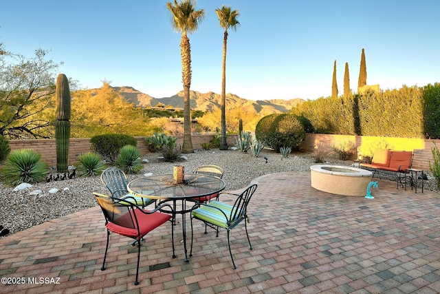 view of patio / terrace with a mountain view and an outdoor fire pit