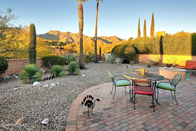 view of patio / terrace with a mountain view and a fire pit