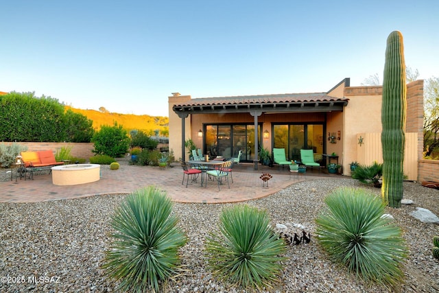 back of property featuring a patio area and a fire pit