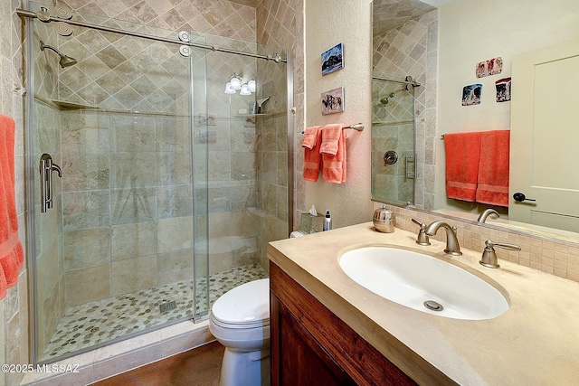 bathroom featuring vanity, an enclosed shower, and toilet