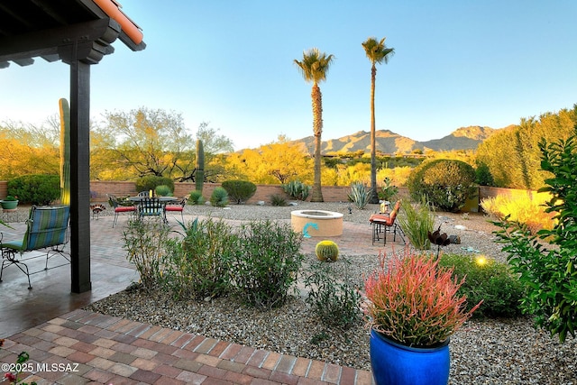 view of yard with a mountain view, a patio area, and a fire pit