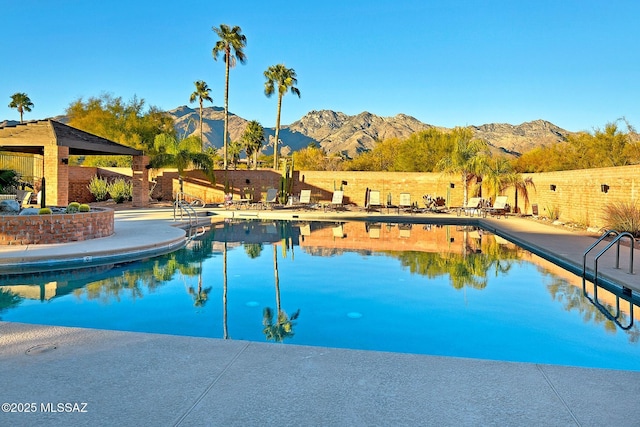 view of swimming pool with a mountain view and a patio area