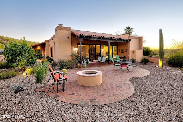 patio terrace at dusk featuring an outdoor fire pit