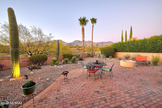 patio terrace at dusk featuring a mountain view