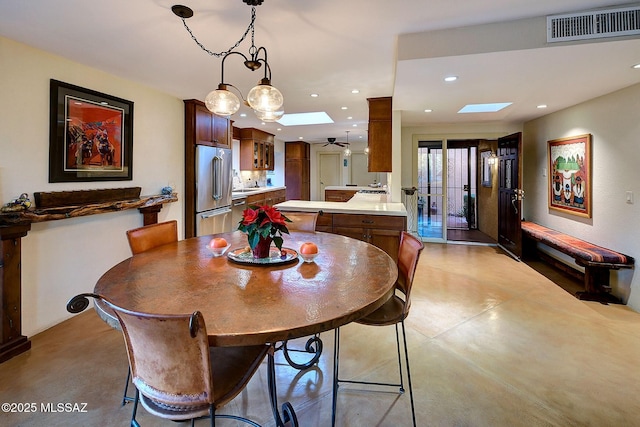 dining space with ceiling fan and a skylight