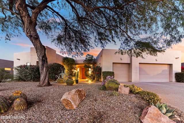 pueblo revival-style home featuring a garage