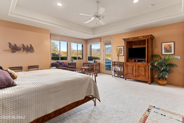 bedroom featuring ceiling fan, a raised ceiling, and carpet floors