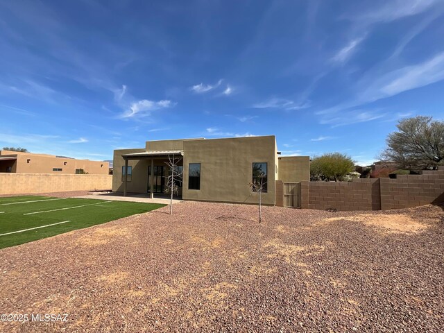 adobe home featuring a garage, driveway, and stucco siding