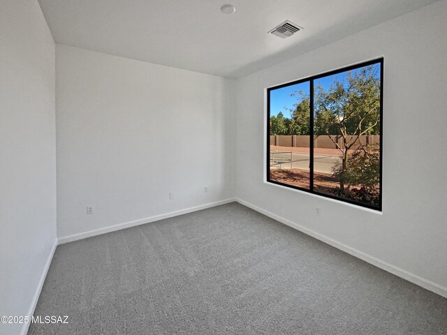 unfurnished room featuring carpet floors, baseboards, and visible vents