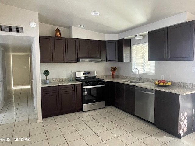 kitchen with light tile patterned flooring, dark brown cabinetry, appliances with stainless steel finishes, and sink