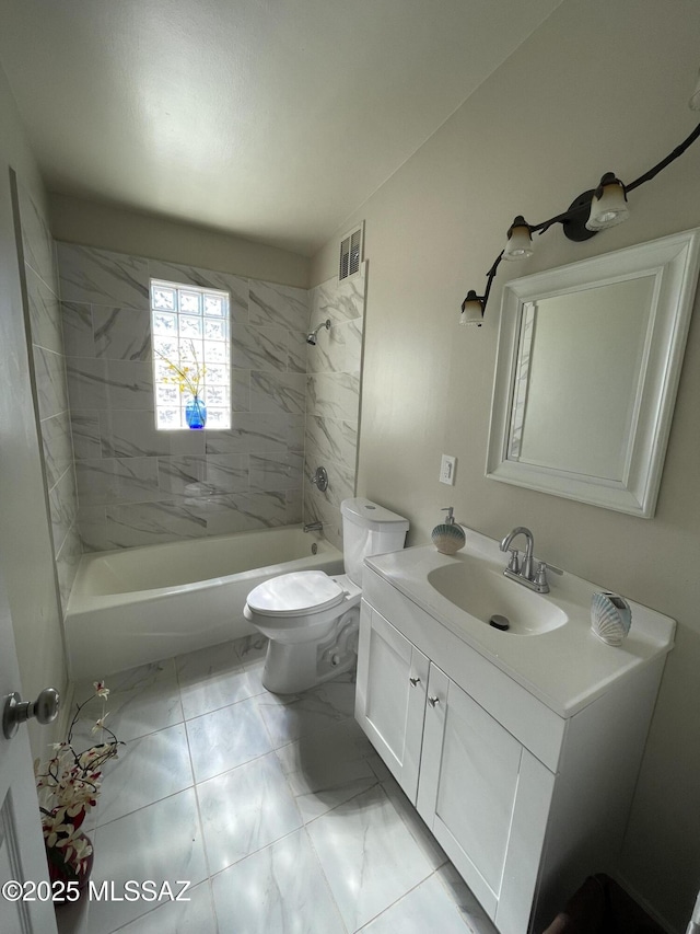 full bathroom with tiled shower / bath, vanity, and toilet