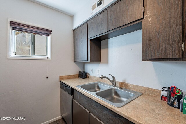 kitchen featuring sink, dark brown cabinets, dishwasher, and stacked washer and dryer