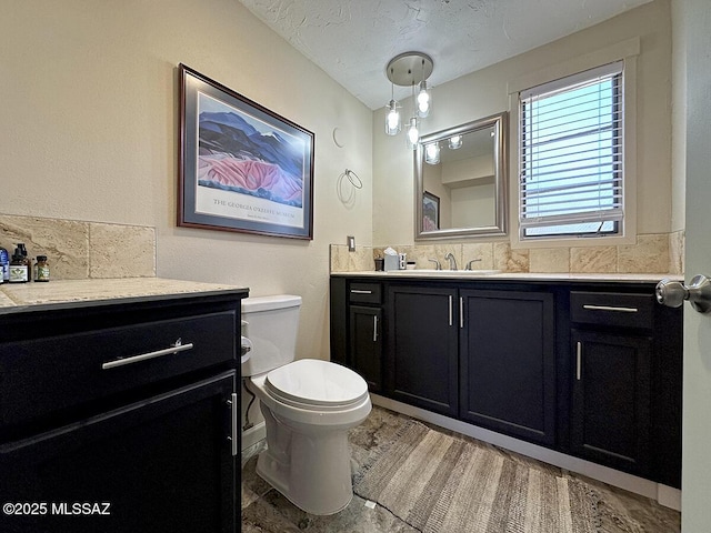 bathroom featuring hardwood / wood-style flooring, a textured ceiling, toilet, and vanity