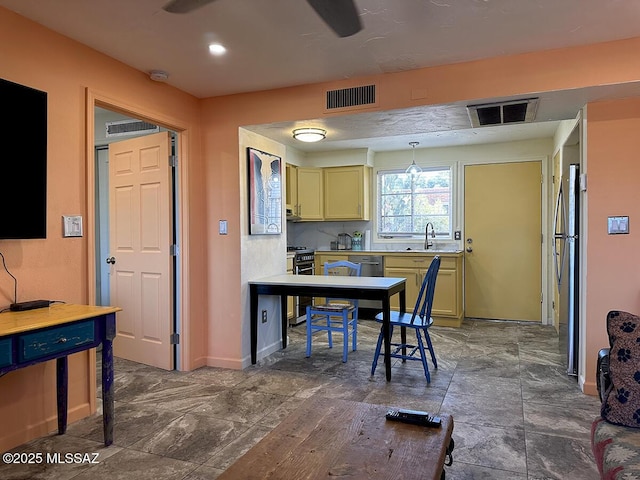 kitchen featuring ceiling fan, appliances with stainless steel finishes, hanging light fixtures, and sink