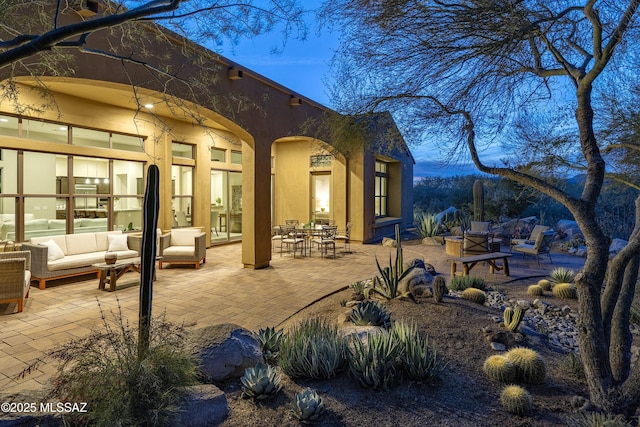 back house at dusk with a patio